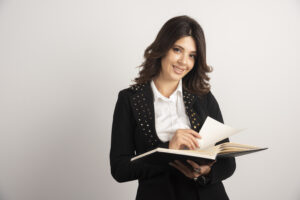 Positive teacher posing with open notebook